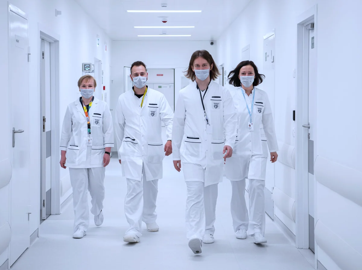 Equipe multidisciplinar de saúde caminhando junta em um corredor hospitalar